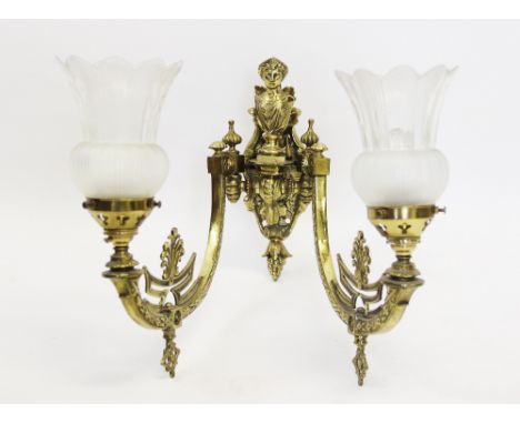 An Edwardian twin branch gilt brass wall sconce, converted from gas, with two branches issuing from a caryatid cast back plat