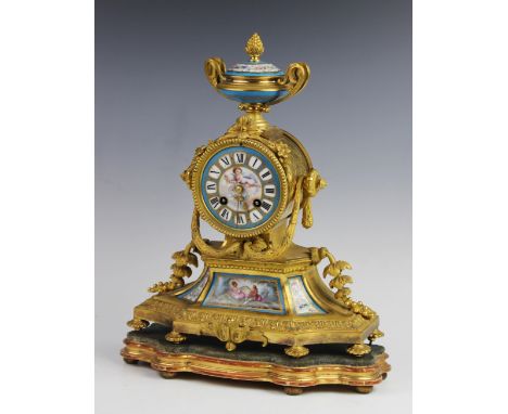 A late 19th century French gilt metal and porcelain inset mantel clock, the two handled urn finial above a 9cm porcelain dial