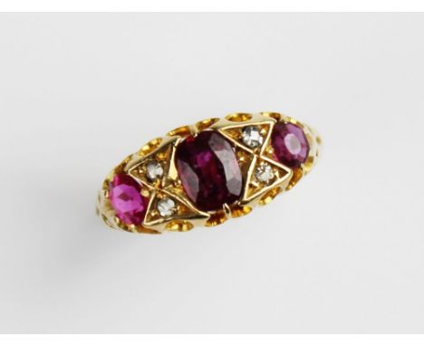 An early 20th century ruby and diamond 18ct gold ring, the central untested oval mixed cut ruby measuring 5.8mm x 4.5mm, with