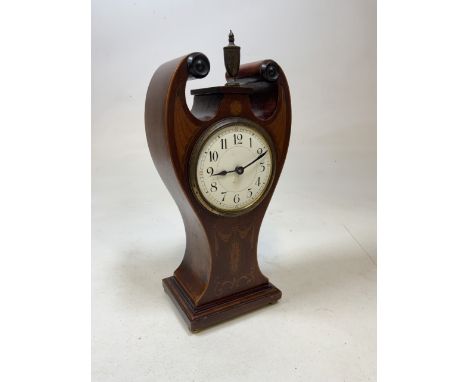Veneered mantel clock with distinctive twin scroll pediment with brass finial to centre. Decorated with inlaid motif. Arabic 