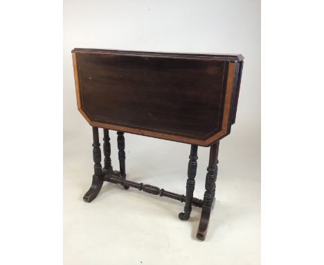 A small Edwardian mahogany inlaid Sutherland table with turned legs and stretcher with ceramic castors, with inlaid shell dec