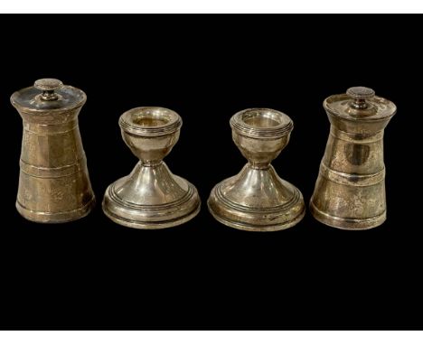 Two silver pepper grinders and pair silver dwarf candlesticks.