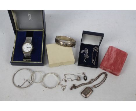 A collection of silver and white metal jewellery to include a hallmarked silver hinged bangle, white metal locket stamped Ste