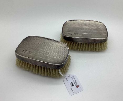 A Pair of Hallmarked Silver Backed Brushes, with engine turned decoration, initialled. (2)