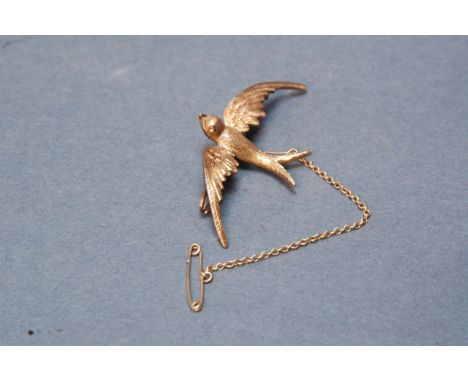 15 ct gold brooch in the form of a swallow.  Wing tip to wing tip 4.5 cm, weight including safety chain 4.7 grams. 