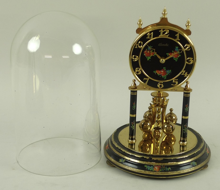 A vintage Kundo anniversary clock, the black dial painted with roses