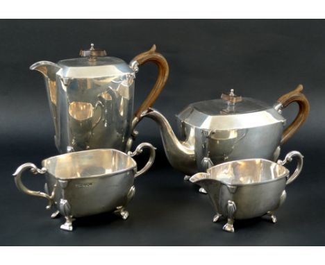 An Art Deco silver tea set of curvilinear design with fruitwood handles and finials, stylised squared paw feet, comprising te