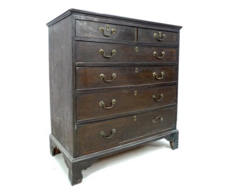 A George III oak chest of drawers, two short above three long drawers, with cock beading, brass swan neck handles and escutch