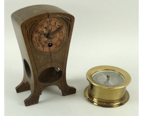 An Art Nouveau mantel clock, the shaped walnut case sinuously carved and inlaid, the hand worked copper dial chased and embos