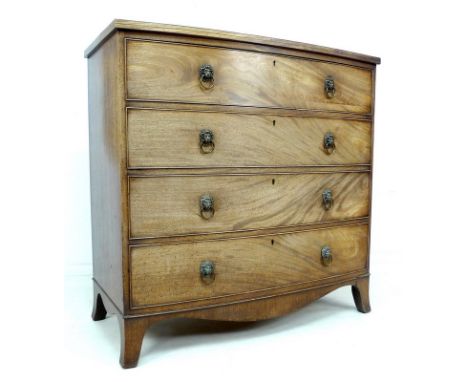 A Regency mahogany bow fronted chest of four graduating drawers, with cock beading and brass lion's mask ring handles, raised