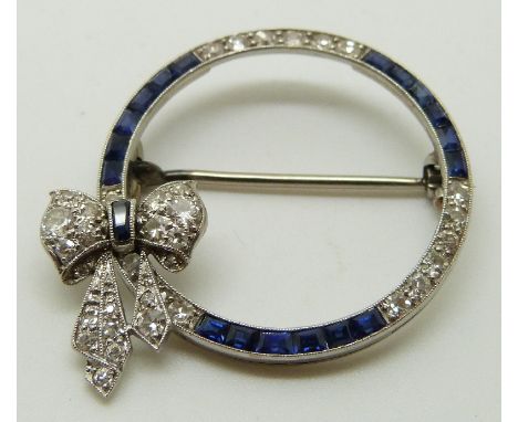 Art Deco platinum circular brooch set with diamonds and sapphires, with bow decoration, 2.8cm diameter