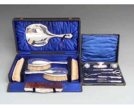 Cased hallmarked silver mounted dressing table set comprising hand mirror, four brushes and a comb, Birmingham 1914, together