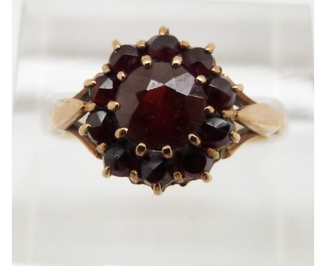 A 9ct gold ring set with an oval cut ruby surrounded by diamonds, 3.7g, size M