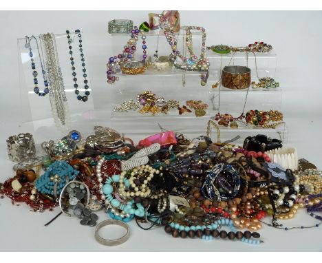 A collection of costume jewellery including white metal brooch set with enamel, silver bangle, beads, etc&nbsp;