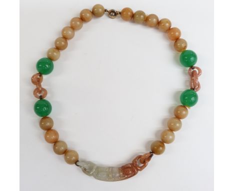 A jade necklace with elongated carved bead suspended from 20 spherical mutton fat beads, four larger spherical apple green be