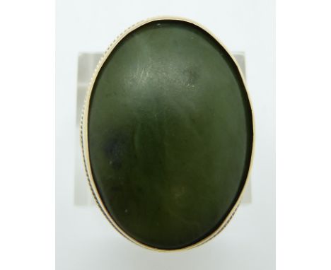 A 9ct gold ring set with a large nephrite jade cabochon, 11.7g, size O
