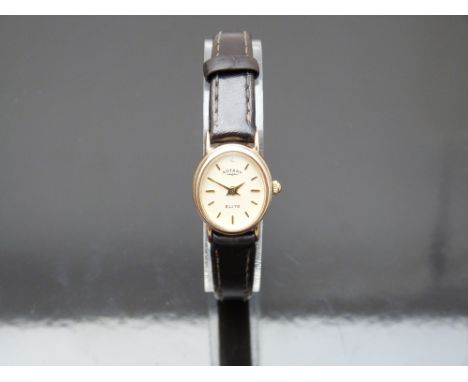 Rotary Elite 9ct gold ladies wristwatch with gold hands and baton markers, champagne dial, oval case and quartz movement, on 