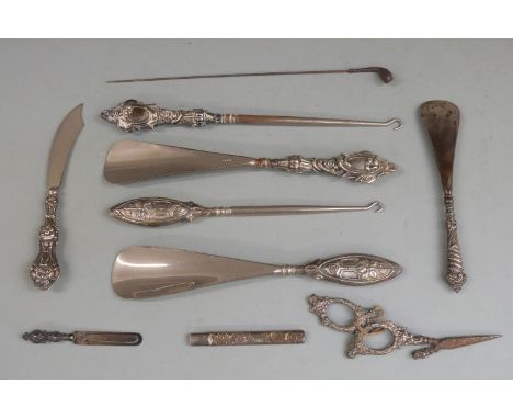 Five hallmarked silver handled button hooks and shoe horns, hallmarked silver novelty golf club hat pin, hallmarked silver pe