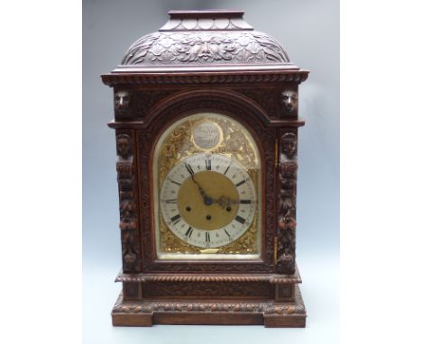 Victorian oak cased mantel/ boardroom clock ornately carved with masks and fruit, the silvered Roman chapter ring and spandre