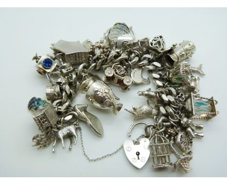 A silver charm bracelet with 42 charms including a Maori tiki, koala, platypus, lamb, cuckoo clock, rabbit, fish etc