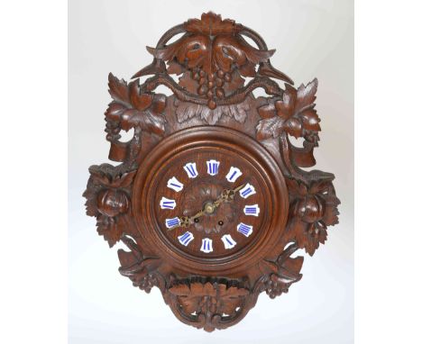 A LATE 19TH CENTURY BLACK FOREST WALL CLOCK, the case carved with fruiting vine, the circular dial with blue Roman numerals a