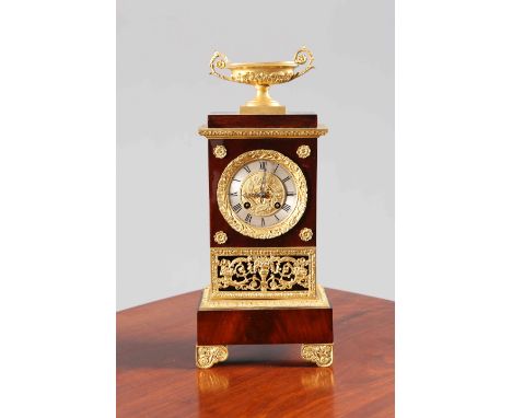 AN EMPIRE STYLE GILT-METAL MOUNTED MAHOGANY MANTEL CLOCK, with urn surmount and fret cast grille below a dial with silvered R