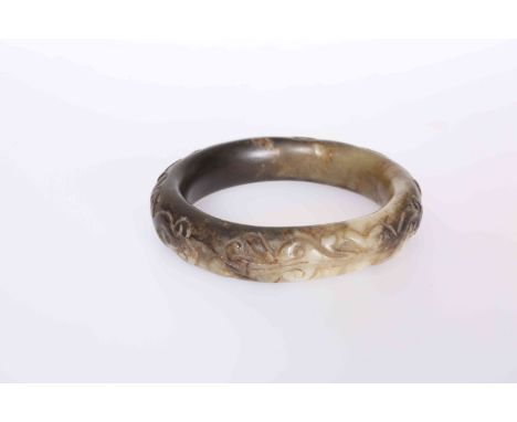 A CHINESE CARVED JADE BANGLE, carved with lizard like creatures. 8.5cm