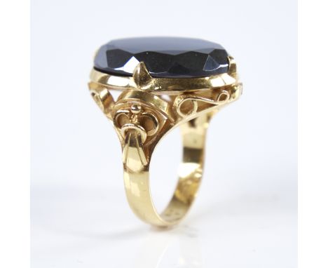 A late 20th century Chinese high carat gold hematite ring, set with a large oval-cut hematite with open scrollwork bridge and