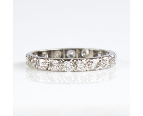 An unmarked white metal diamond eternity ring, total diamond content approx 0.8ct, band width 2.7mm, size K, 2.1gGood overall