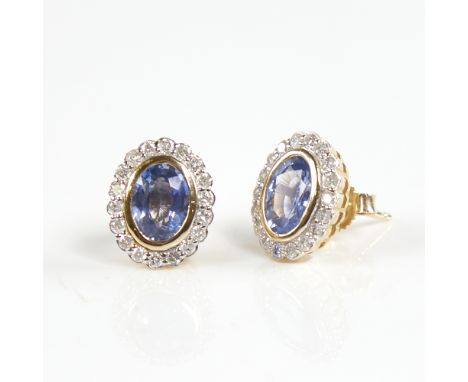 A modern pair of 14ct gold sapphire and diamond cluster stud earrings, set with oval-cut sapphires surrounded by round brilli