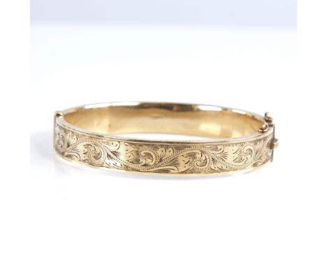 A mid-20th century 9ct gold hinged bangle, engraved foliate decoration, hallmarks Birmingham 1961, band width 10mm, internal 