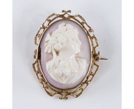 An early 20th century relief carved pink coral cameo brooch/pendant, depicting Classical female profile bust, in unmarked gol