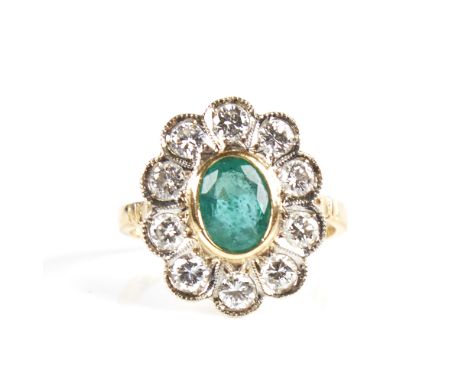 A Continental unmarked gold emerald and diamond cluster flowerhead ring, total diamond content approx 1ct, setting height 18m