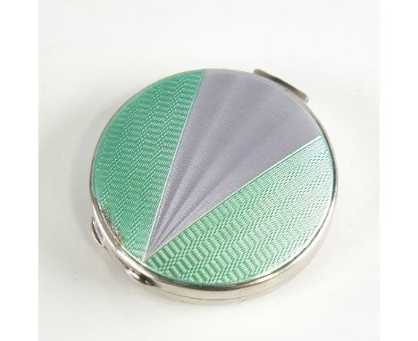 A George V Art Deco silver and enamel circular compact, engine turned green and silver enamel decorated lid with gilt interio