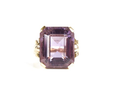 A large late 20th century 9ct gold step-cut amethyst ring, openwork lozenge bridge with raised shoulders, amethyst length 16.