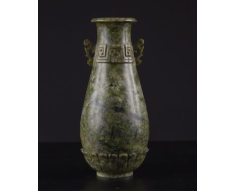 A jade vase China, Qing Dynasty, 18th Century Archaistic style carved from a block of green stone with dark mottling and imit