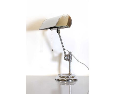 A chromed table lamp,1930s, with an articulating arm and shade, raised on a stepped circular foot with a central recess,45cm 