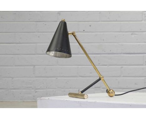 An Italian brass and enamel desk lamp,1960s, with a conical black enamel shade, with an adjustable mount, raised on a ball an