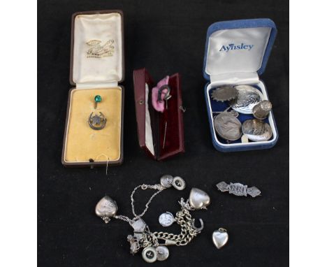 A collection of silver and white metal jewellery including charm bracelet, heart shaped lockets, cufflinks, brooches, two coi