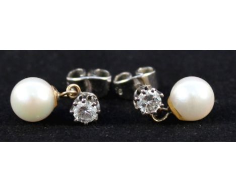 A pair of white metal diamond stud earrings with pearl drops