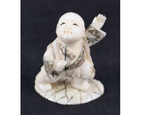 A Japanese ivory netsuke of a reclining lady with flowers