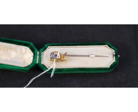A yellow metal yachting pin with enamel flag decoration