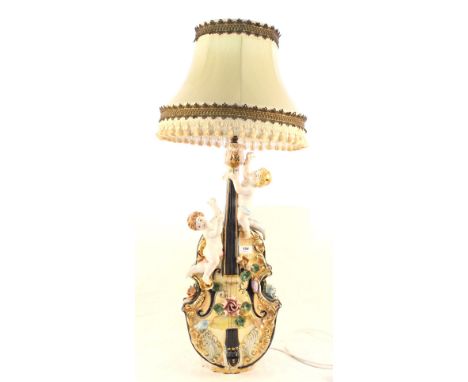 An Italian china table lamp of violin form with cherub mounts