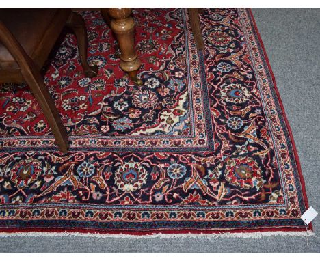 Kashan carpet, the raspberry field of vines around an indigo medallion framed by spandrels and meandering vine borders, 347cm