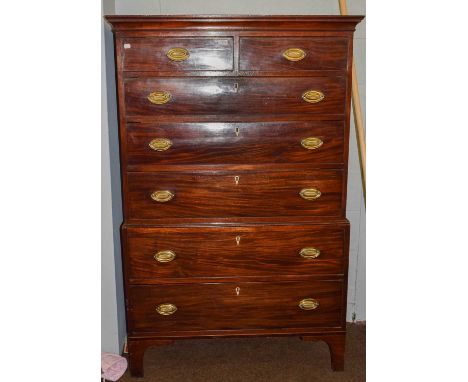 A George III mahogany chest on chest with oval brass handles, ivory escutcheons, and raised on bracket feet, 101cm by 47cm by