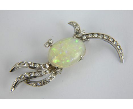 A stylish diamond and opal brooch, white metal mount marked 750, the central opal surrounded by abstract branches set with ro