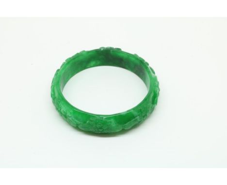 Jadeiet bangle with flowerd, diam. 7 cm.Handgesneden jadeiet armband met bloemen, diam. 7 cm.