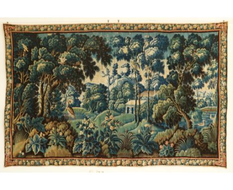 A Flemish verdure tapestry Late 17th Century Woven in wools and  silks, depicting a wooded hilly landscape with a lake to the