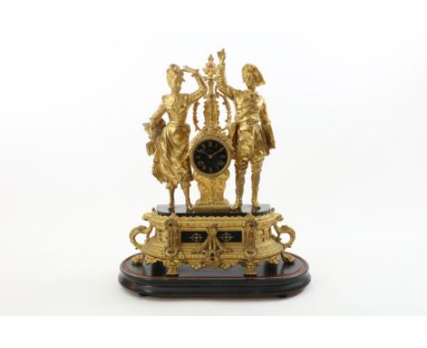 Gilded Zamak mantel clock, the timepiece flanked by lady and lord, address Fatin, on oval wooden pedestal, France late 19th c