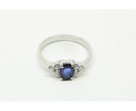 White gold ring mounted with blue sapphire 0.90ct. and brilliants  0.24ct. 750/000, size 17Witgouden fantasiering bezet met b